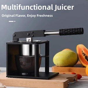 Detail of manual stainless steel press with anti-slip handle and juice cup on wood board