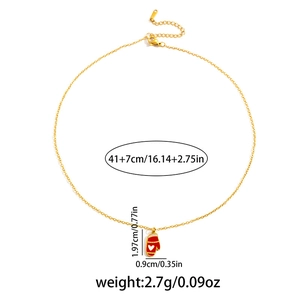 Detailed view of festive gold necklace with red glove pendant and heart motif detail