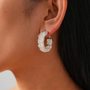 Detailed view of silver woven mesh hoop earrings with a unique textured nest pattern finish