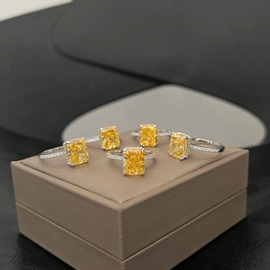 Dettaglio di gemme gialle taglio radiant incastonate in anelli d'argento S925 lucidi
