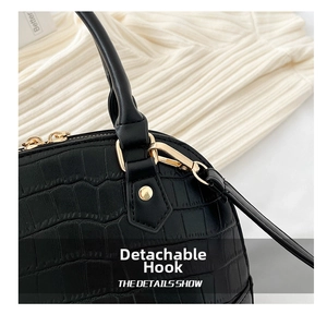 Detailed macro view of black crocodile pattern leather and gold detachable metal hook