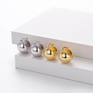Detailed view of polished S925 sterling silver ball earrings in gold and silver finishes