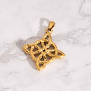 Vue détaillée d'un pendentif nœud celtique doré sur une surface en marbre gris