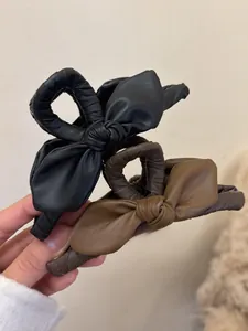 Dettaglio di fermagli per capelli in pelle vintage nero e marrone con trama fine
