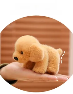 Handheld view of a small golden plush dog keychain with soft furry texture
