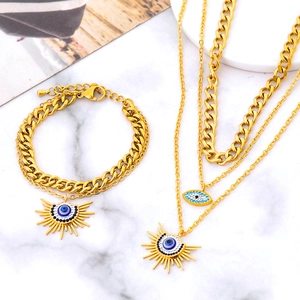 Ensemble collier à trois rangs et bracelet en acier doré avec pendentifs œil et soleil