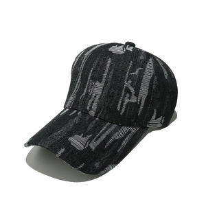 Detailed view of striped baseball cap featuring monochrome abstract patterns and curved brim