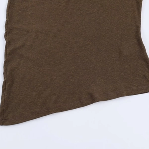 Gros plan sur la texture du tricot marron foncé et les coutures de finition de l'ourlet