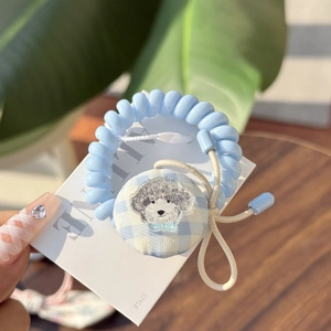 Blue spiral hair tie detail featuring an embroidered grey poodle motif on a round charm