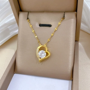 Close-up of golden heart pendant with large round zircon and sparkling accents in a box