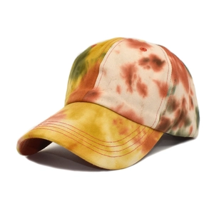 Close-up of a tie-dye baseball cap with multi-color orange and yellow twill fabric