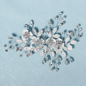 Detail shot of a silver bridal hair clip with intricate pearl flowers and sparkling crystals