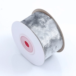 Macro view of wide silver-grey velvet ribbon roll showing soft texture and glossy finish