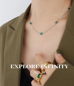 Model wearing vintage emerald green zircon necklace and gold square emerald ring detail