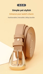 Detail of light brown faux leather belt with fine grain texture and gold pin buckle