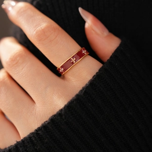 Macro detail of vintage 18k gold plated ring with red enamel and zircon flowers