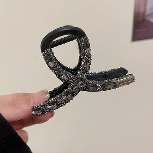 Close-up of black rhinestone claw clip showing sparkling grey crystals and premium finish