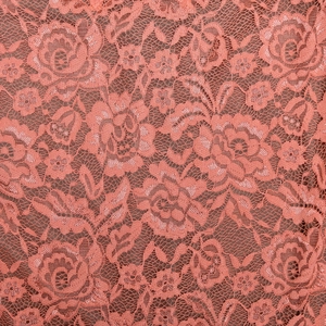Gros plan sur la dentelle rose corail montrant les motifs floraux et la texture mesh