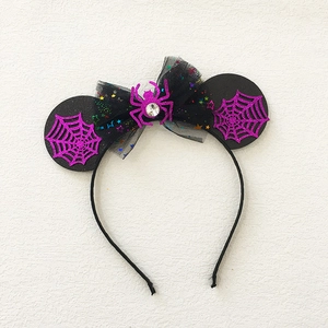 Macro shot of Halloween headband with purple spider web ears and sequined bow detail