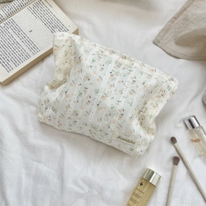 Détail de la trousse à maquillage florale montrant la texture coton et dentelle douce