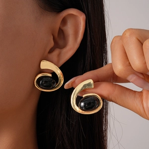 Vue détaillée de boucles d'oreilles spirales dorées avec pierre noire ovale vintage
