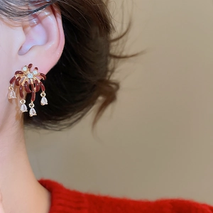 Detail of vintage gold plated firework earring with dark red enamel and zircon stones