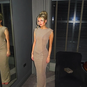 Detailed view of shimmering gold sleeveless bodycon maxi dress with ruched slit details