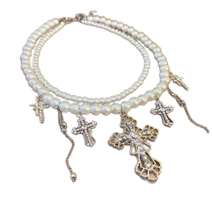 Double-layer pearl necklace with silver cross pendants and rhinestone tassels on white