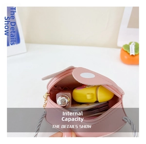 Detail showing inner capacity of pink rabbit crossbody bag with lipstick and earbuds