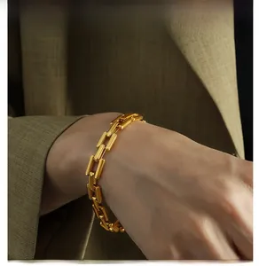 Detail of 18k gold plated cuban link bracelet styled on a camel suit wrist for men
