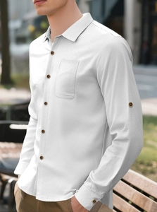 Detailed texture of white linen shirt fabric featuring amber buttons and chest pocket