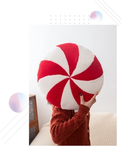 Close-up of peppermint spiral pattern on soft red and white plush Christmas pillow