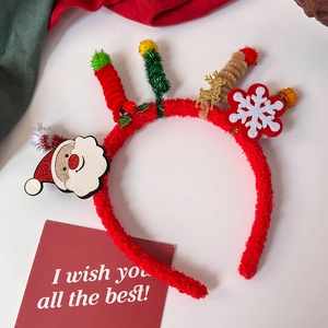 Flat lay of a plush Christmas headband featuring Santa, deer, and festive decorations