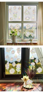 Detailed view of floral suncatcher stickers creating rainbow prism light on window glass