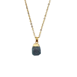 Close-up of deep blue raw stone pendant with irregular gold plating on fine chain