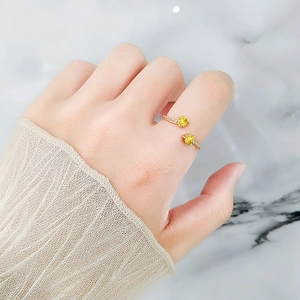 Adjustable gold open ring featuring two yellow heart-shaped cubic zirconia on hand