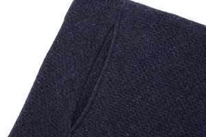 Vue macro détaillée de la texture du tricot bleu foncé et des coutures fines