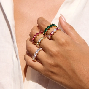 Macro shot of gold-plated stacked eternity rings set with colorful zircon stones