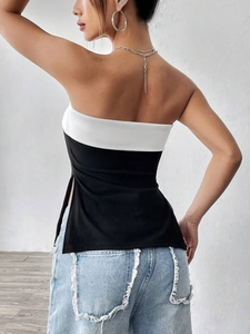 Achteraanzicht van zwart-witte strapless top met zijsplitjes en denim korte broek