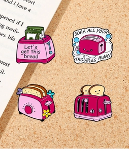 Detail von vier rosa Cartoon-Toaster-Emaille-Pins mit englischen Sprüchen zum Thema Brot