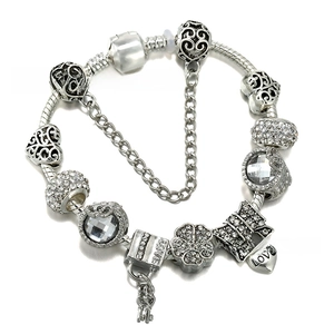 Close-up of vintage silver plated charm bracelet featuring heart lock and crystal beads