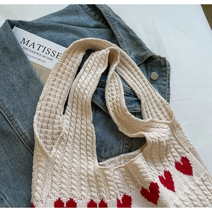 Primer plano del bolso de punto con motivos de corazones rojos y textura suave
