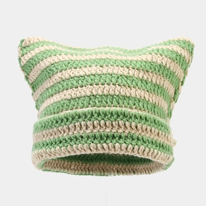 Close-up of green and white striped crochet knit texture on a cat ear beanie hat