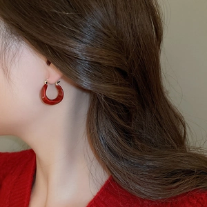Boucles d'oreilles en U plaquées or 14K avec émail rouge sur modèle en vue de profil
