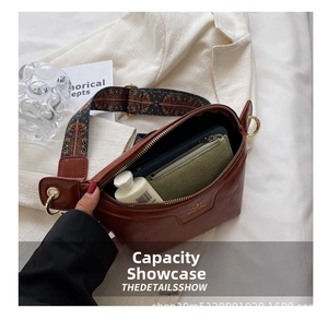 Interior view showing capacity of brown leather crossbody bag with ethnic wide strap