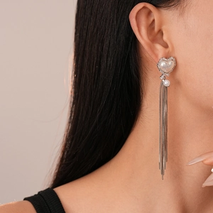 Detailed view of silver long fringe earrings with heart pearls and sparkling zircon