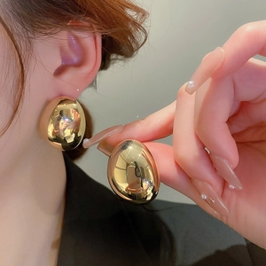Exaggerated gold oval drop earrings with polished metallic finish for women