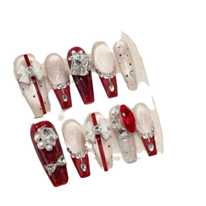 Red bow press-on nails with champagne cat-eye glitter and rhinestones in long coffin shape