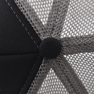 Macro view of mesh baseball cap crown with fabric-covered button and detailed stitching