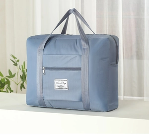 Detail of light blue waterproof travel bag with reinforced straps and front zipper pocket